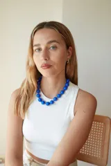 Collar de cuentas esféricas grandes de acrílico blanco, ensartadas en un cordón claro.