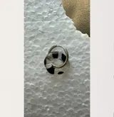 Aros de argolla con dije circular de cristal de Murano transparente con diseño de tablero de ajedrez en blanco y negro.