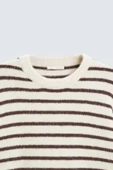 Jersey de punto color crudo con rayas horizontales marrones, cuello redondo y manga larga.