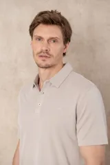 Remera celeste de corte clásico, con cuello polo abotonado y mangas cortas.