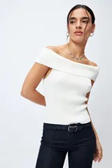 Top tejido color blanco con escote bardot que deja los hombros al descubierto y punto acanalado.
