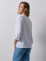 Blusa blanca texturada marca Ruby Rd, con escote redondo y mangas 3/4 con puño elastizado y apliques de broderie. Confeccionada en poliéster y elastano.