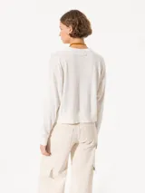 Sweater tejido suave y flojo, color crudo, con cuello redondo y mangas largas.