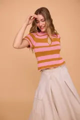 Remera polo tejida a rayas color beige y crudo, con cuello polo, escote en V y mangas cortas.