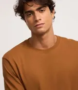 Remera de manga larga color blanco, confeccionada en algodón, con cuello redondo y puños ajustados.