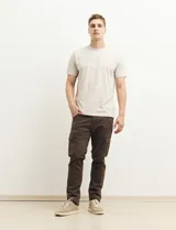 Pantalón de gabardina color marrón, corte slim fit, con bolsillos laterales tipo cargo.