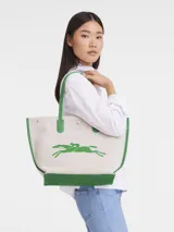 Bolso shopper Longchamp modelo Le Roseau Essential, color crudo con detalles en verde. Presenta logo de la marca en verde y doble asa de hombro.