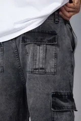 Pantalón jean azul de corte ancho, estilo cargo, con bolsillos laterales y detalles metálicos.