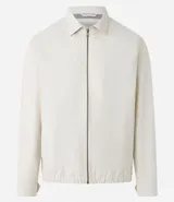Campera color crema de sarga lisa, con cuello camisero, cierre frontal con cremallera, bolsillos delanteros, puños abotonados y bajo elástico.