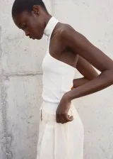 Top blanco de punto fino con cuello halter y diseño entallado.