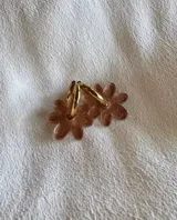 Aros colgantes con forma de flor color rosa con glitter y aro dorado.