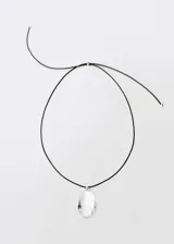 Collar con cordón negro ajustable y dije de vidrio transparente en forma de lágrima.