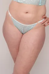 Tanga de tiro alto color celeste, confeccionada en puntilla elastizada y LYCRA®. Tiras regulables en los costados. Fundillo en algodón 100%.