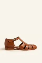 Sandalias de cuero color marrón claro, con diseño de tiras entrecruzadas y hebilla lateral.
