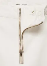 Pantalón de jean blanco de corte wide leg con tiro medio y cierre frontal con cremallera.