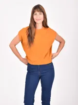 Remera de manga corta, color naranja quemado, con cuello redondo y mangas caídas que simulan un efecto de hombro doblado.