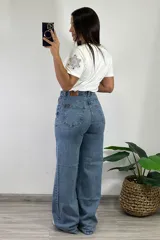 Pantalón jean celeste de tiro alto, corte wide leg y bolsillos delanteros y traseros.