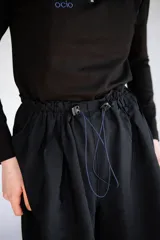 Bermuda holgada negra con cintura elastizada y hebillas de ajuste.