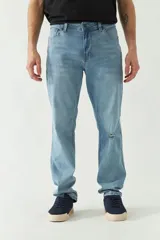 Pantalón de jean celeste de corte recto, con cintura regular y tiro medio. Presenta un pequeño agujero en la rodilla derecha y logo bordado en el bolsillo delantero. Confeccionado en algodón con spandex.