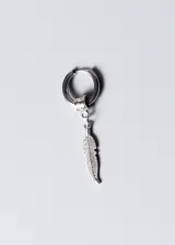 Aro de acero quirúrgico plateado con dije colgante de pluma tallada. El aro es de tipo argolla con cierre a presión y tiene un pequeño adorno con diseño griego. El dije de pluma es alargado y delgado, con detalles grabados que simulan las barbas de la pluma.