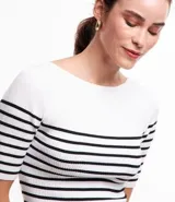 Blusa de punto con textura acanalada, escote barco y mangas 3/4. Diseño a rayas horizontales blancas y negras.