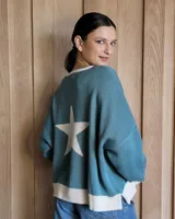 Buzo celeste con una estrella blanca en la espalda y detalles en blanco en el cuello y el ruedo.