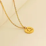 Collar dorado con dije redondo con el signo de Aries grabado.