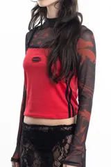Top deportivo rojo con breteles finos y ribete negro, con logo ovalado en el pecho y dos líneas verticales negras en los laterales.