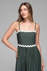 Vestido midi azul marino con tirantes finos y escote recto. Presenta detalles ondulados blancos en el busto, la cintura y el ruedo.