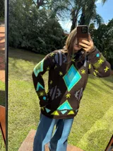 Sweater tejido de lana color azul marino con diseño geométrico en blanco.