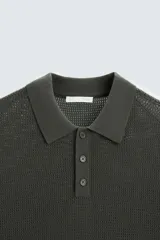 Polo de punto color verde oscuro, con cuello solapa y cierre frontal de botonadura.