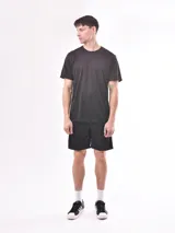 Remera negra de poliéster con cuello redondo y mangas cortas.