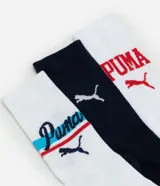 Kit de tres pares de medias Puma de caña alta, confeccionadas en algodón más sostenible. Incluye un par blanco con logo rojo, un par azul marino con logo blanco y texto, y un par blanco con logo y diseño deportivo en azul y rojo.