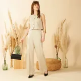 Blusa color beige sin mangas con botones frontales y cuello redondo.