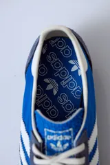 Championes Adidas SL 72 con estampado animal print, cordones naranjas y las tres tiras clásicas en blanco.