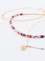 Set de tres collares dorados de diferentes largos. Uno es una cadena de eslabones, otro es una cadena de bolitas doradas y el tercero es una cadena fina con bolitas y un dije redondo con una inscripción.