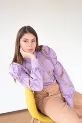 Camisa lila con estampado de flores amarillas, de manga larga con puños elásticos y cuello clásico.