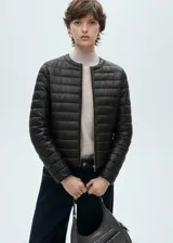 Campera acolchada negra con cierre frontal y cuello redondo.