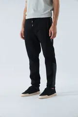 Pantalón de jogging gris oscuro de felpa con puños, cintura ajustable con cordón y logo estampado en la pierna.