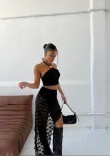 Pollera midi de encaje negro con tajo lateral y terminación irregular.