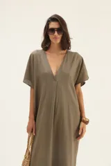 Vestido largo color visón, de lino, corte amplio, mangas cortas tipo murciélago y escote en V.