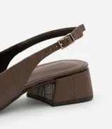 Zapato de tacón marrón con textura de cocodrilo, modelo slingback, con puntera fina, taco bloque mediano y cierre por hebilla.