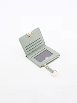 Billetera verde de cuero sintético con cierre de cremallera y llavero circular dorado.