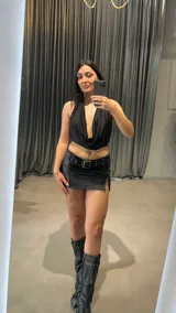 Top negro con escote drapeado tipo halter y espalda descubierta.