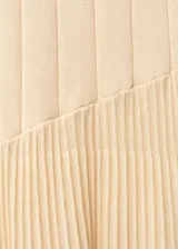 Vestido largo color durazno, de tejido de punto fino con diseño plisado y evasé. Sin mangas y con cuello halter.