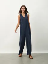 Mono largo color beige, de corte holgado, con cuello redondo y mangas cortas. Presenta bolsillos laterales y detalle de costuras verticales en el frente.