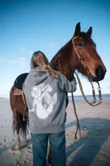 Buzo canguro gris con capucha y cordones ajustables. Estampado en la espalda con una sirena, una flor de hibisco y la frase "Glass Waves".