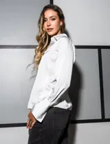 Camisa blanca de satén, marca Tahari. Cuello con solapa y escote en V. Abertura central con botones. Manga larga con puño y botón.