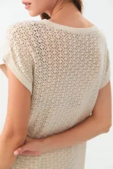 Remera de tejido calado color crudo, de corte recto y mangas cortas.