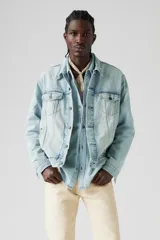 Campera de jean celeste claro, con cuello clásico, cierre frontal con botones metálicos y bolsillos con solapa abotonada en el pecho.